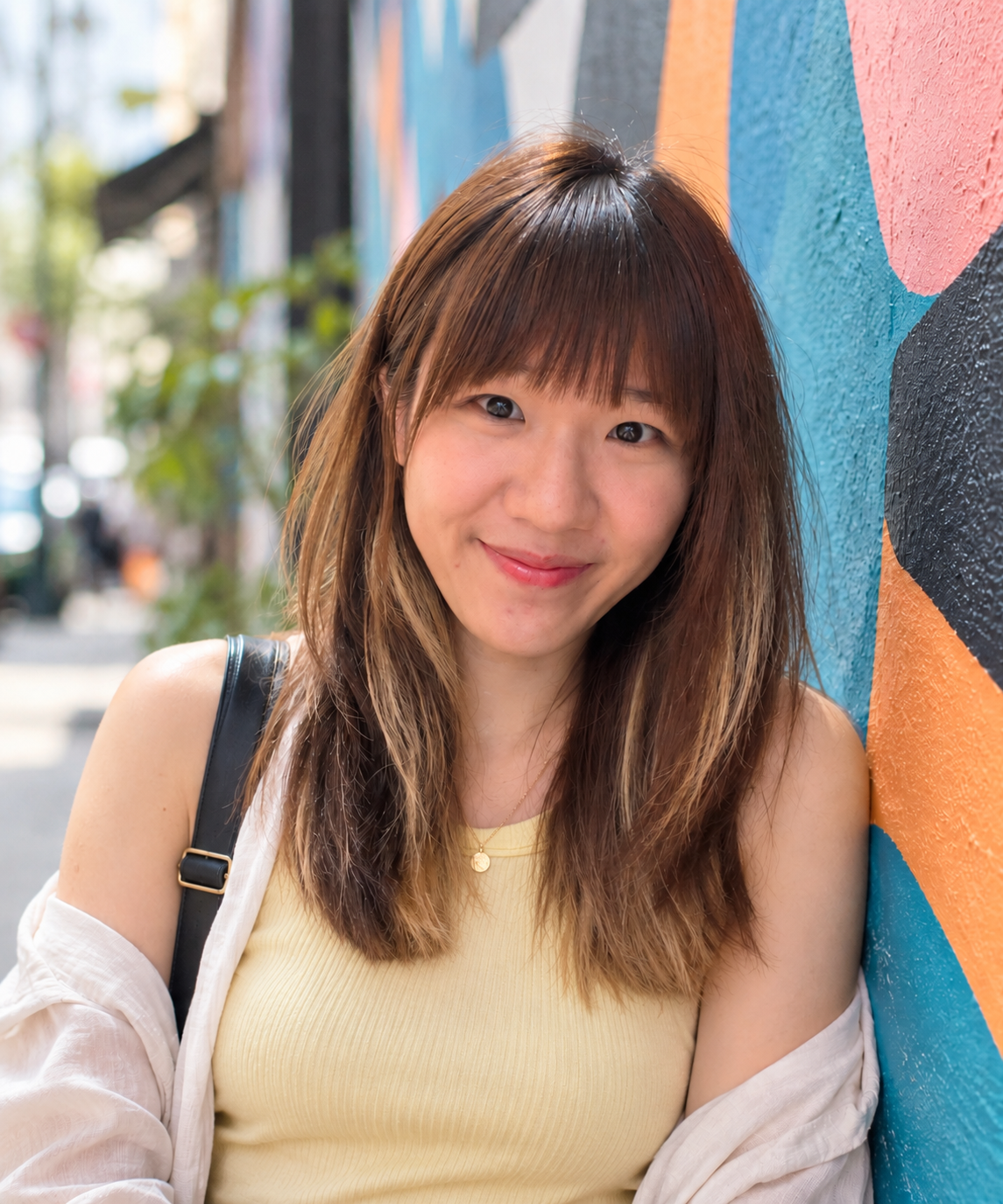 Chloe smiling beside a colourful mural